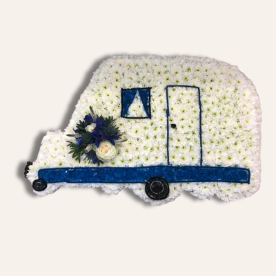 Caravan-shaped funeral tribute made with white chrysanthemum, sprayed detailing, and laminated accents, finished with optional mixed floral focal in chosen colours, measuring approximately 89cm x 51cm.