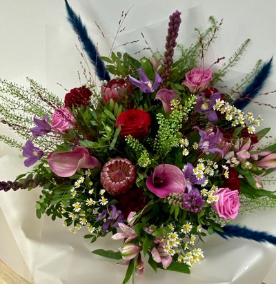 Ruby Jewel bouquet with roses, calla lily, clematis, liatris and pampas grass in jewel-toned shades.