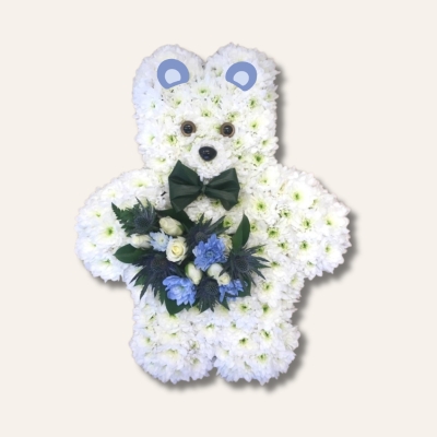 Teddy bear funeral tribute with white chrysanthemums, bow tie, and blue and white focal flowers