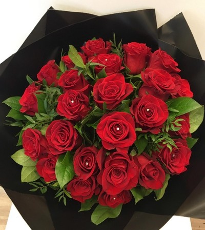 Luxurious bouquet of 24 large-headed red roses with sparkling diamante centres, complemented by foliage, wrapped in luxury cellophane and matching gift bag, hand-tied in water.