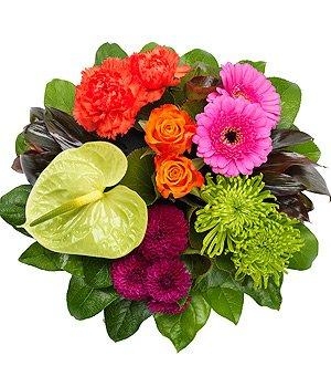 Vibrant funeral posy pad with orange, pink, green, and purple seasonal flowers, grouped in a modern style and finished with lush foliage.