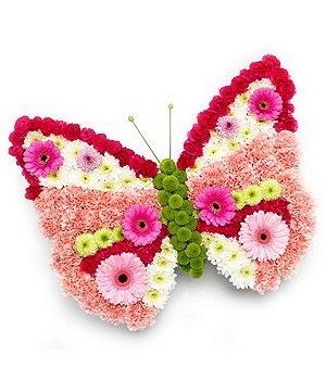 Butterfly-shaped funeral tribute made with mixed fresh flowers including roses, carnations, chrysanthemums and germini, measuring approximately 36 inches by 24 inches.