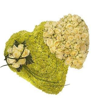 Double heart funeral tribute with white roses, green carnations, and a white rose spray with lily grass accents.