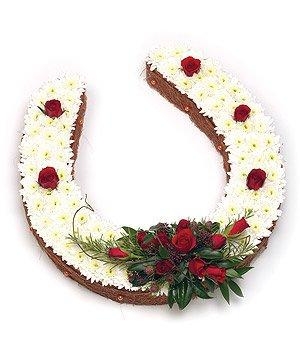 Horseshoe funeral tribute with white chrysanthemum base, red rose spray, and foliage, customisable upon request. 