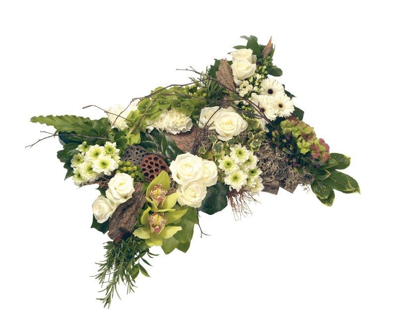 Textured green and white pillow funeral tribute with luxury flowers and lush green foliage.
