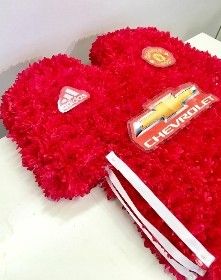 Manchester United shirt funeral tribute with fresh flower base, pipework detailing and printed waterproof badges, 21 x 21 inches, available in classic and modern shirt versions.