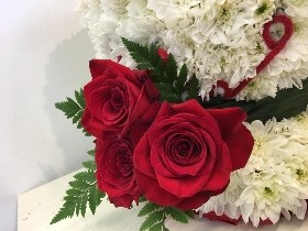 3D tea cup-shaped funeral tribute made with white chrysanthemum, detailed with carnations, roses, foliage, and ribbon, measuring approximately 35cm high by 35cm wide.