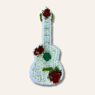 Guitar-shaped funeral tribute made with white chrysanthemum, mixed floral focal in chosen colours, and detailed with grass strings and Kermit chrysanthemum tuning pegs, measuring approximately 97cm high by 38cm wide.