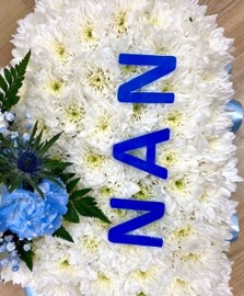 Heart-shaped funeral tribute with laminated wording, white chrysanthemums, delicate ribbon edge, and matching focal. Customisable colour options available.