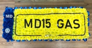 Registration plate funeral tribute created with a chrysanthemum base, , and personalised detailing on a 12 by 30 inch board.