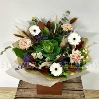 Woodland Whisper bouquet with white gerbera, blush carnations, berries and autumn grasses in natural gift wrap.