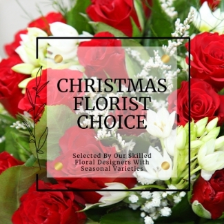Hand-tied Christmas florist choice bouquet with mixed festive seasonal flowers in a signature gift bag.