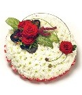 White chrysanthemum funeral posy with red ribbon edging and a red focal, complemented by lush foliage. Customizable color options available.